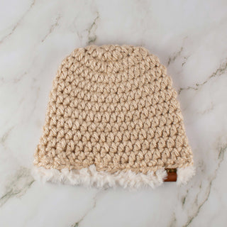 Beige satin lined winter hat with a white faux fur trim.