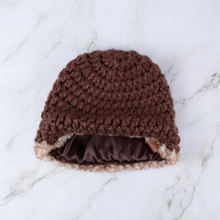 Brown satin lined winter hat with a brown and white faux fur trim.