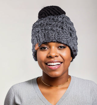 Woman wearing a charcoal satin lined ponytail beanie. Messy bun hat.