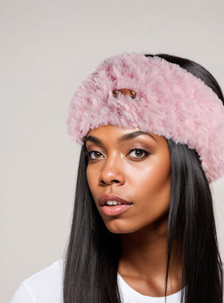 Woman with long straight hair wearing a faux fur satin lined winter headband in pink.