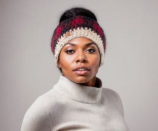 Woman wearing a buffalo plaid, satin lined winter headband in red and black.